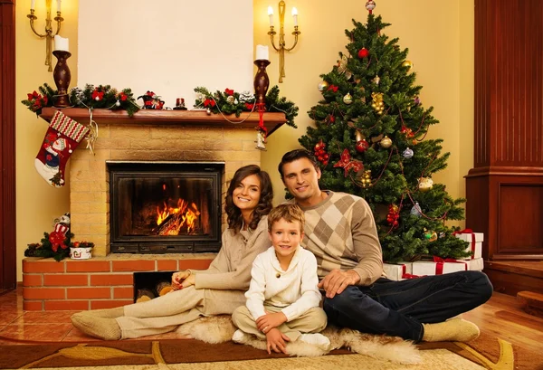 Familia cerca de la chimenea en Navidad decorado interior de la casa — Foto de Stock