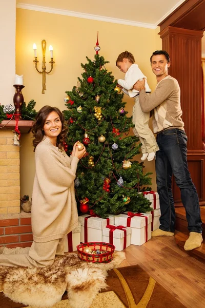 Glückliche Familie schmückt Weihnachtsbaum — Stockfoto