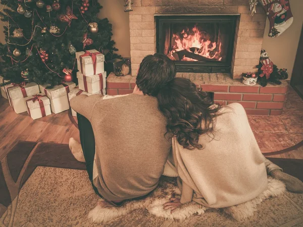 Pareja cerca de la chimenea en Navidad decorado interior de la casa —  Fotos de Stock