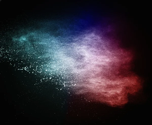 Colourful powder exploding isolated on black — Stock Photo, Image