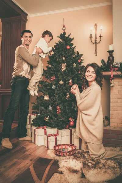 Familia cerca de la chimenea en Navidad decorado interior de la casa con caja de regalo —  Fotos de Stock