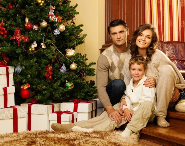 Familia feliz cerca del árbol de Navidad en el interior de la casa —  Fotos de Stock