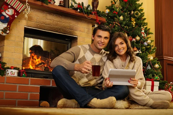 Pareja cerca de la chimenea en Navidad decorado interior de la casa — Foto de Stock