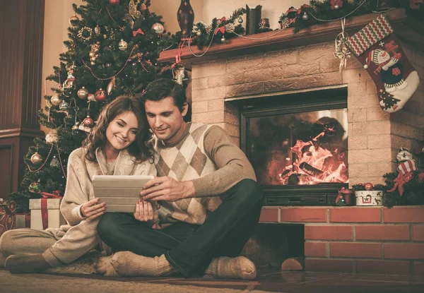 Couple près de la cheminée dans la maison décorée de Noël intérieur — Photo