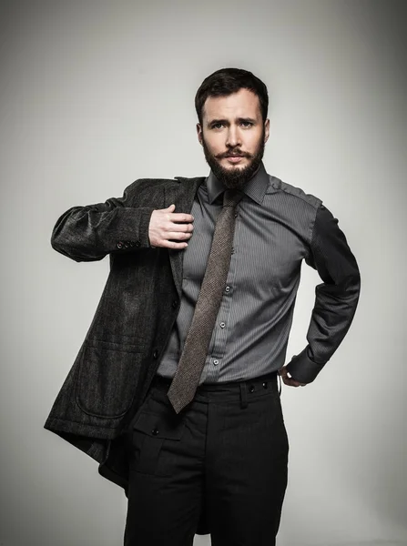 Handsome man with beard putting on jacket — Stock Photo, Image