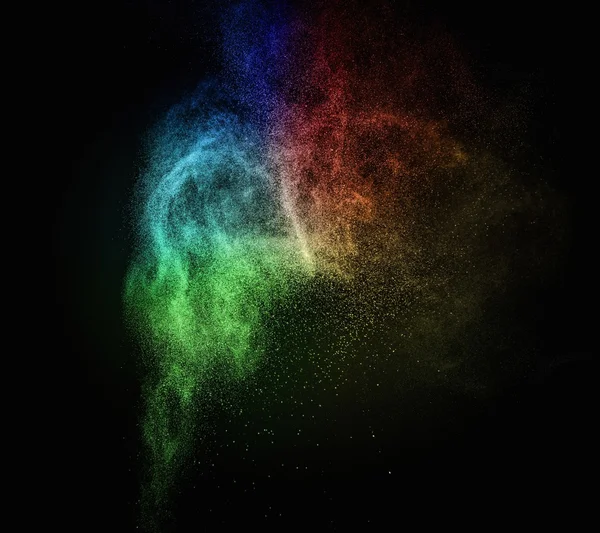 Colourful powder exploding isolated on black — Stock Photo, Image