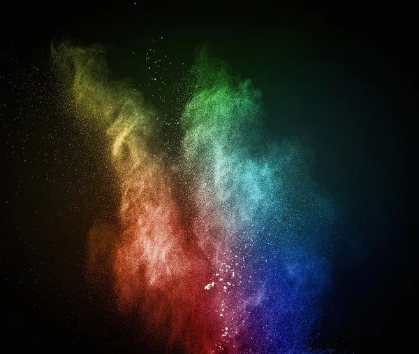 Colourful powder exploding isolated on black — Stock Photo, Image