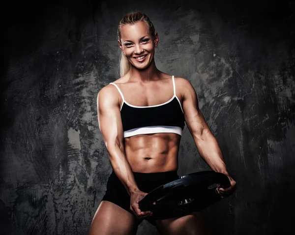 重みを持つ美しい筋肉ボディービルダーの女性 — ストック写真