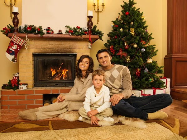 Familia cerca de la chimenea en Navidad decorado interior de la casa — Foto de Stock