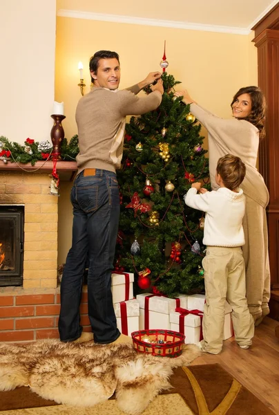 Happy family decorating Christmas tree — Stock Photo, Image