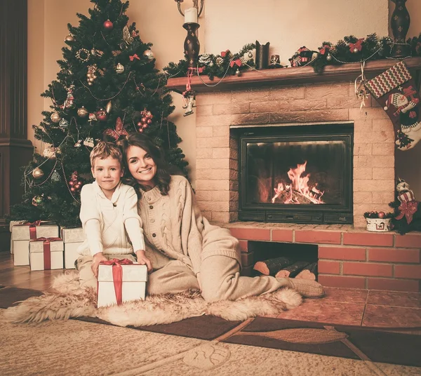 Glückliche Mutter mit ihrem Sohn im weihnachtlich dekorierten Haus — Stockfoto