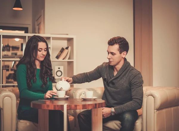 Young couple drinking coffee during discussion — Stock Photo, Image