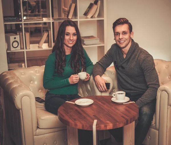 Young couple drinking coffee during discussion — Stock Photo, Image