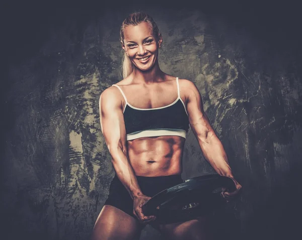 重みを持つ美しい筋肉ボディービルダーの女性 — ストック写真