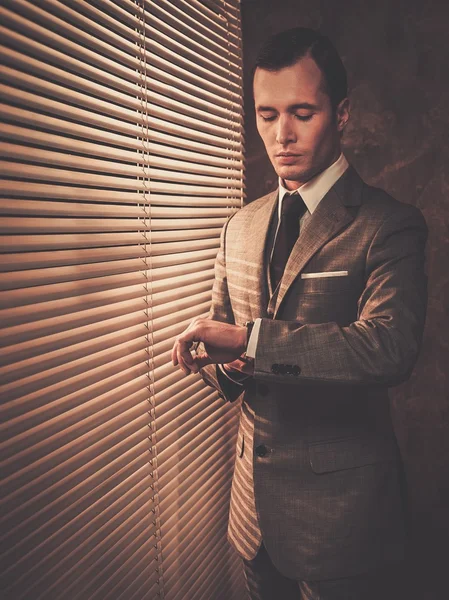 Man met een glas in de buurt van een venster — Stockfoto