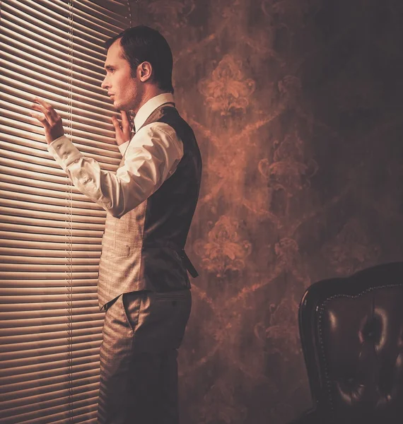 Hombre bien vestido mirando a través de jalousie —  Fotos de Stock