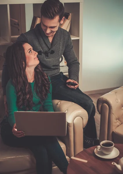 Ungt par med laptop och kaffe efter bord — Stockfoto