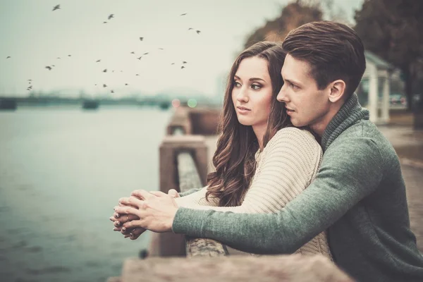秋の濃霧発生日に川の近くの美しい若いカップル — ストック写真
