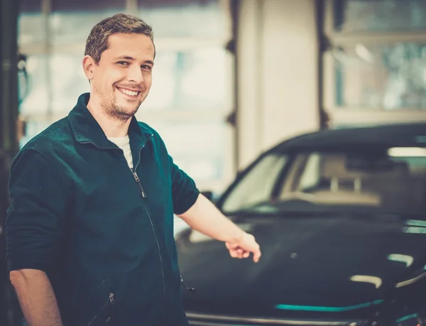 Hombre trabajador lavando coche de lujo en un lavado de coches — Foto de Stock