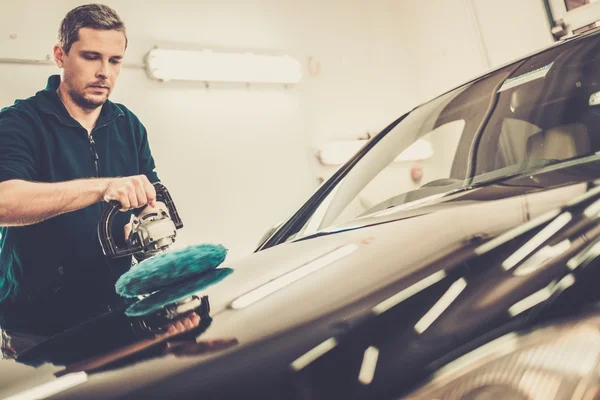 Mann in Waschanlage poliert Auto mit Poliermaschine — Stockfoto