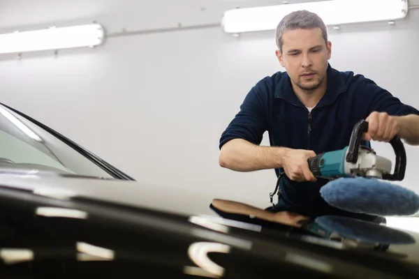 Hombre en un coche lavado pulido coche con una máquina de pulido — Foto de Stock