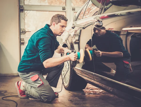 Man on a car wash polishing car with a polish machine — Stock Photo, Image