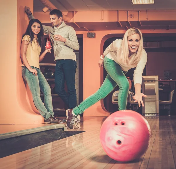 Блондинка усміхнена дівчина кидає м'яч у боулінг-клуб — стокове фото