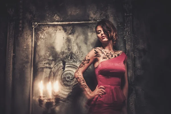 Tattooed beautiful woman in old spooky interior — Stock Photo, Image