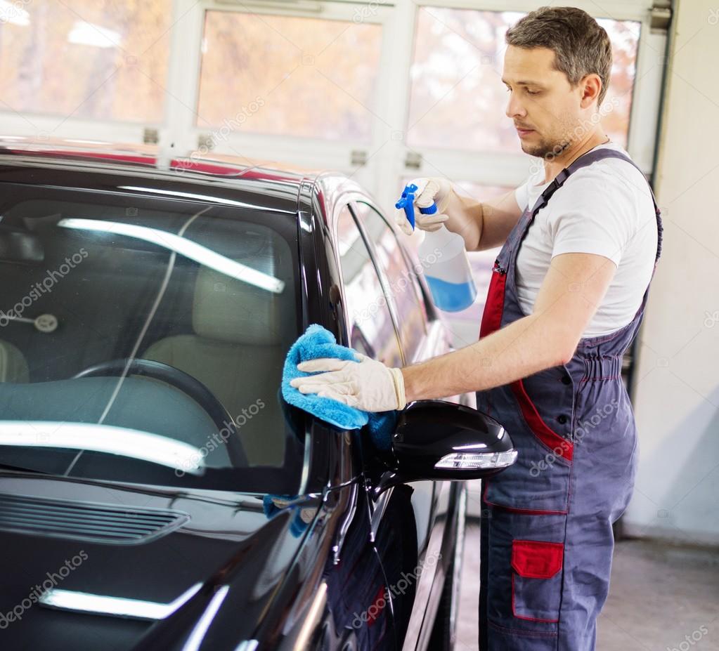 Worker on a car wash cleaning car with a spray — Stock Photo © nejron