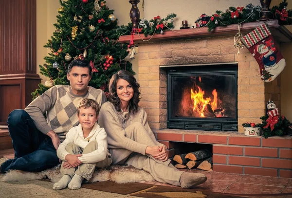 Familia cerca de la chimenea en Navidad decorado interior de la casa — Foto de Stock