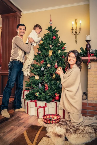 Glad familj dekorera julgran — Stockfoto