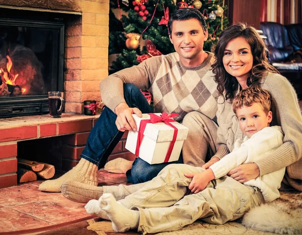 Familie in de buurt van open haard in Kerstmis ingericht huis interieur — Stockfoto