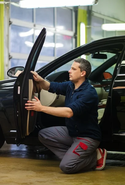 Worker on a car wash cleaning car interior — Stock Photo, Image