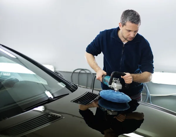 Mężczyzna na myjni samochodowej polerowanie samochodu z polerki — Zdjęcie stockowe