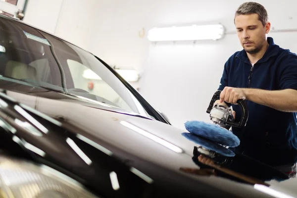 Mann in Waschanlage poliert Auto mit Poliermaschine — Stockfoto