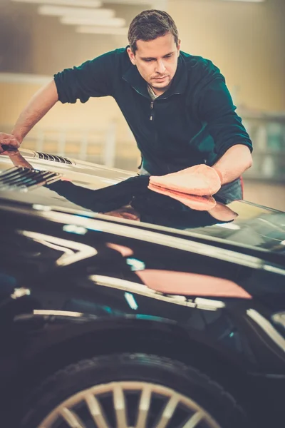 Uomo lavoratore lucidatura auto su un autolavaggio — Foto Stock