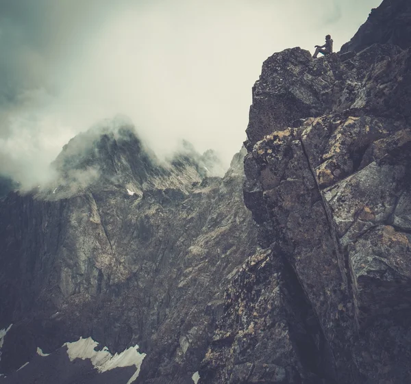 Woman hiker sitting on a mountain peak — Stock Photo, Image