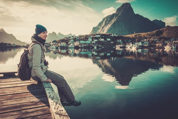 Žena sedí na molu v vesnice Reine, Norsko — Stock fotografie