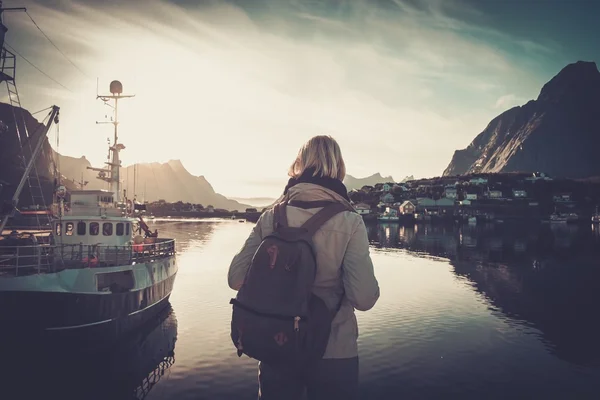 Vrouw reiziger op zoek bij zonsondergang in Reine dorp, Noorwegen — Stockfoto