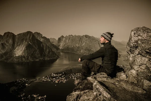 Bărbat excursionist uitându-se la panorama satului Reine, Norvegia — Fotografie, imagine de stoc