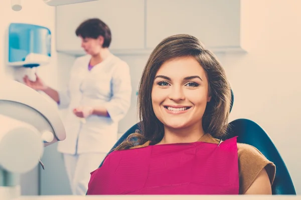 Jonge mooie brunette vrouwelijke tandarts op van tandarts chirurgie — Stockfoto