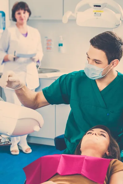 Молодая красивая брюнетка-дантист на операции стоматолога — стоковое фото