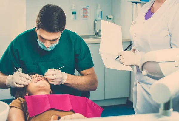 Jeune belle brune dentiste féminine à la chirurgie du dentiste — Photo