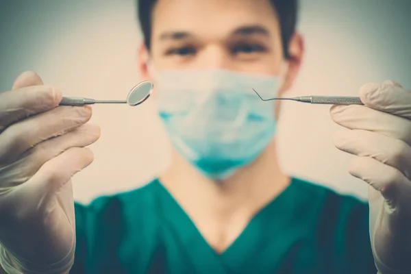 Young man dentist holding dental tools — Stock Photo, Image