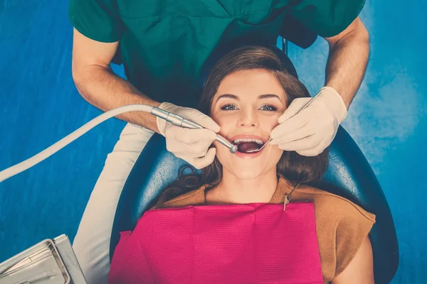 Young beautiful brunette female dentist at dentist's surgery — Stock Photo, Image