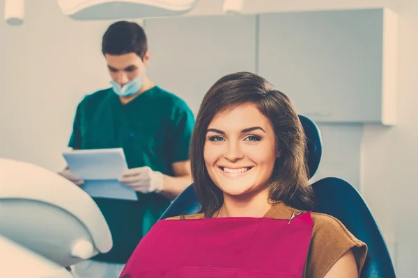 Young beautiful brunette female dentist at dentist's surgery — Stock Photo, Image