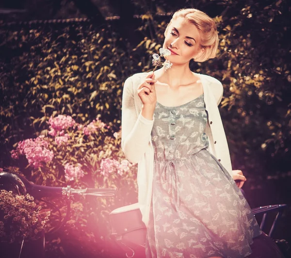 Beautiful blond woman sitting on a retro roller — Stock Photo, Image