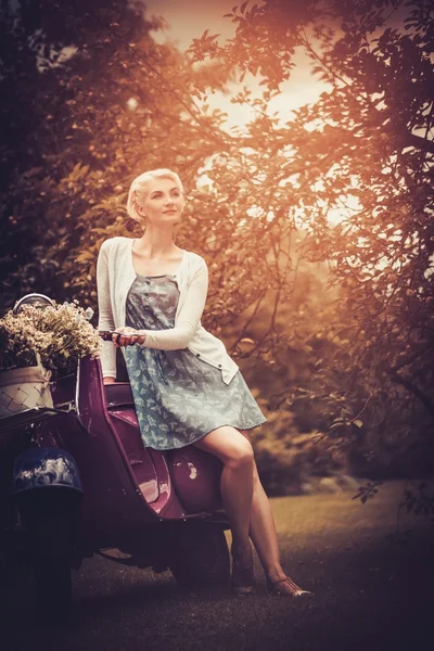 Красивая блондинка сидит на ретро-роллере — стоковое фото