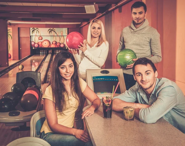 ボーリング クラブ内のテーブルの後ろに若い人たちのグループ — ストック写真