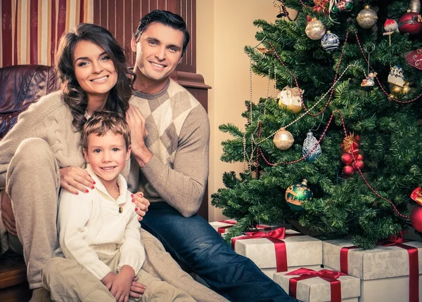 Happy family near Christmas tree in house interior — Stock Photo, Image